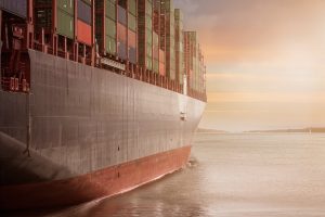 cargo ship in water overlooking sunset